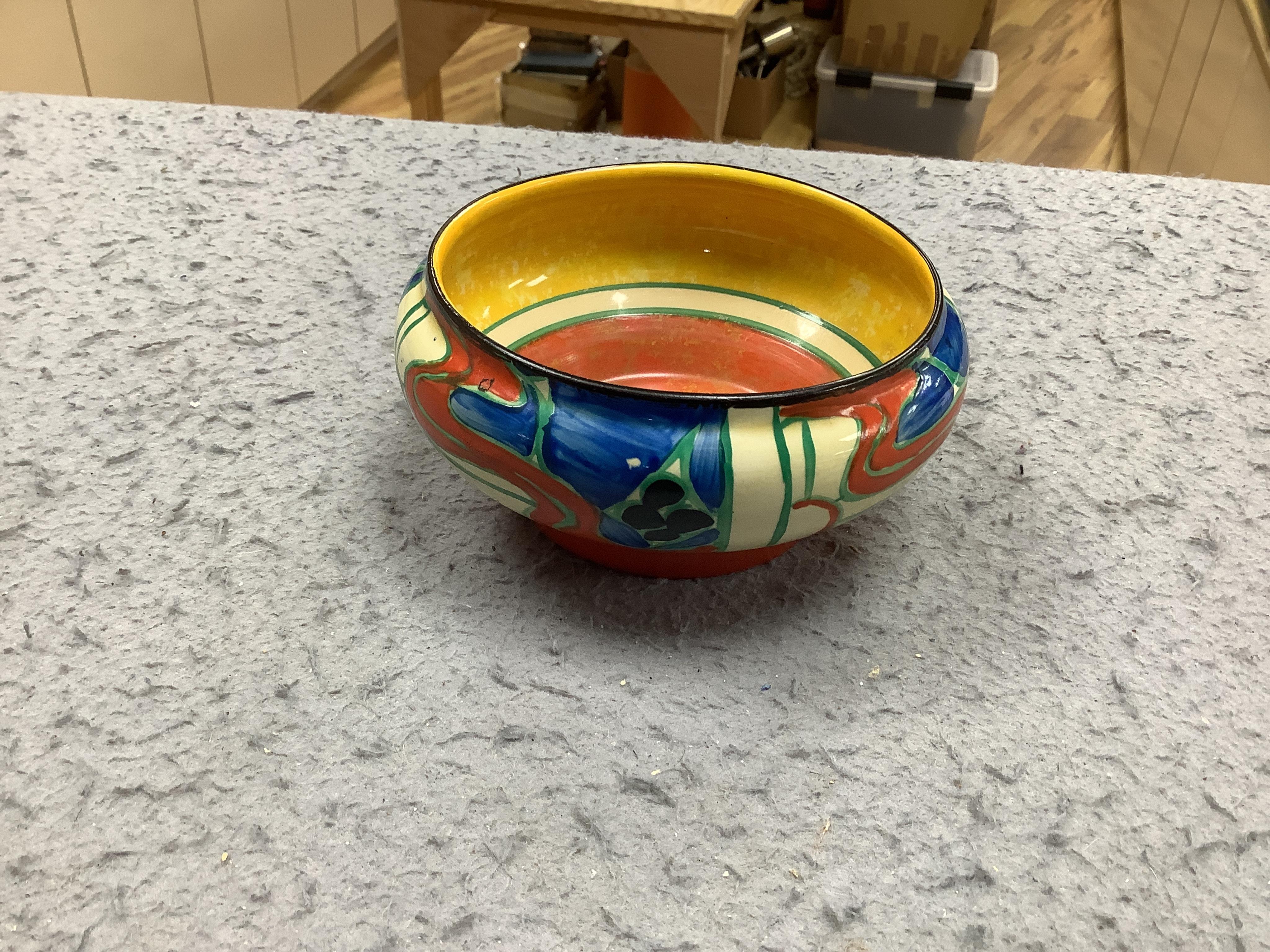 A small Clarice Cliff 'Fantasque' bowl, top rim 11cm diameter. Condition - minor chips to enamelling.